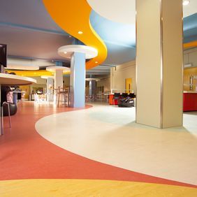 Bright homogeneous flooring laid in various patterns to add colour to hospital canteen