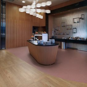 Self service breakfast bar area with Oak effect flooring laid alongside Polysafe Verona 