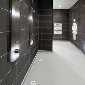 Grey coloured safety flooring in a public ladies shower area 