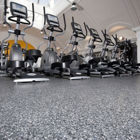 Gym studio with bike machines and dark coloured flooring