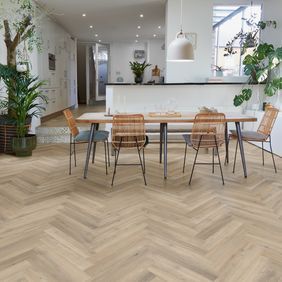 Oak effect flooring laid in a herring bone style in a seating area with table and chairs