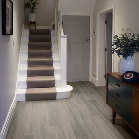Dark oak effect flooring laid in a large hallway 
