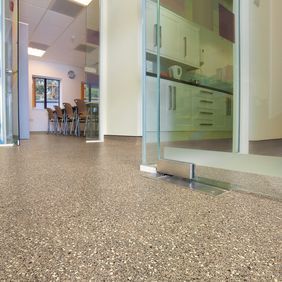 Neutral coloured safety flooring in a corridor 