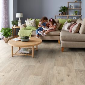 Oak effect flooring laid in a sitting room with children reading on the couch