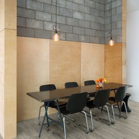 Black meeting table open brick walls with wood panelled walls and Grey Oak flooring 