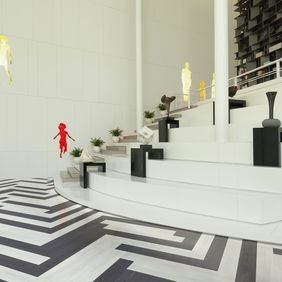 Black and white ash wood effect flooring laid in a herringbone design in a art gallery 