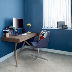 Home desk with computer and chair featuring a light concrete effect flooring 