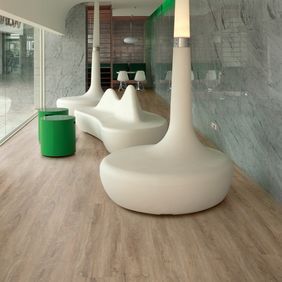 Modern glass window waiting area with white seating and oak plank pattern flooring