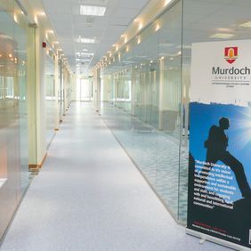 Light blue flooring in a long university corridor