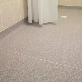 Close up of wet room with light grey flooring