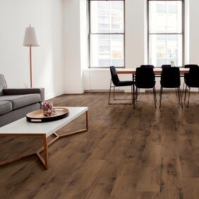 Dark coloured oak effect flooring laid in an apartment open plan living space
