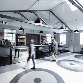 Various shades of grey coloured flooring to create a circle design floor in a canteen area 