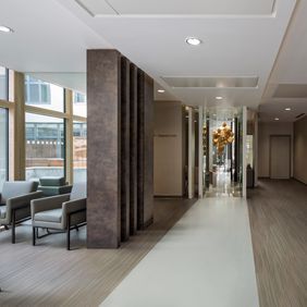 Light concrete effect flooring laid alongside oak effect flooring to create a walkway and seating area