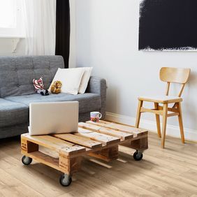 Light oak wood effect flooring in a living room with blue sofa and a rustic coffee table 