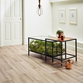 Light oak wood effect flooring in a home with table and plants 
