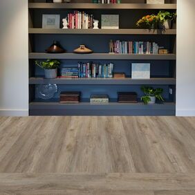 TLC Original in Courtyard Oak laid in front of a book/ornament shelf