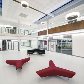 Pale grey flooring in a large waiting area in a highschool 