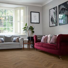 Dark oak effect flooring laid in a large parquet style within a front room