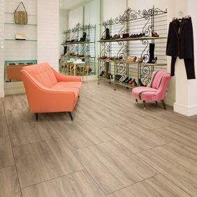 Modern shoe retail store with orange seating and Oak plank pattern flooring 