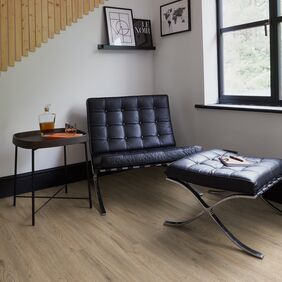 Seating area, leather chair, foot rest, wood panel wall, oak style flooring 