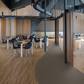 Canteen area with dining tabels and chairs, Huckleberry oak flooring laid alongside Exopna Flow Taupe 