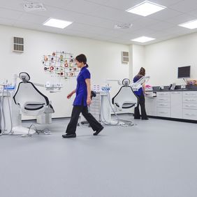 Light blue safety flooring in a Dentist room with chairs and dental nurses