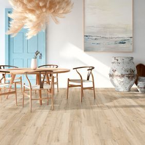 Light oak effect flooring in a room with a small wood dining table and chairs