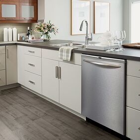 Dark wood effect flooring laid in a kitchen with white units