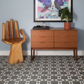 Tiled effect LVT in a hallway with abstract art on the walls and obscure hand chair
