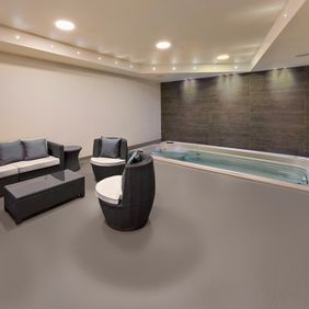 Brown colour safety flooring in a spa relaxation area with seating and hot tub