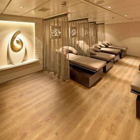 Therapy room with massage beds featuring a ligh oak effect flooring 
