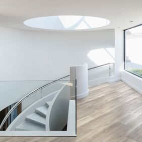 White curved staircase, glass window, oak style floor