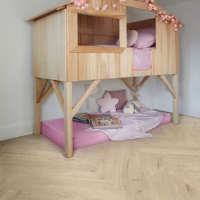 Oak effect flooring laid in a parquet style in a little girls bedroom