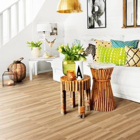 Ash wood effect flooring in a living room space with white sofa and bright accessories 
