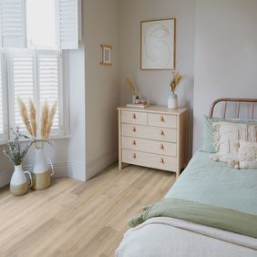 Oak effect flooring laid in a boho style bedroom
