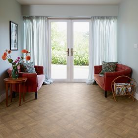 Basket weave style flooring in a sitting room with patio doors and an orange couch