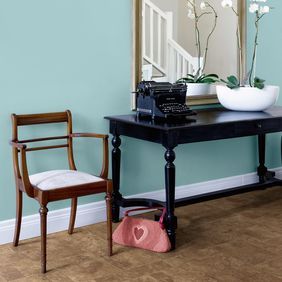 Brown paving effect flooring in a hallway with a table console and mirror 