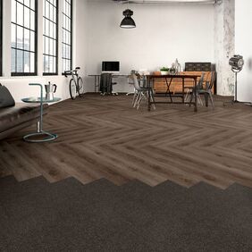 Dark oak effect flooring laid i a parquet style in a modern office