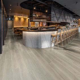 Trendy bar area with stools and wood effect flooring