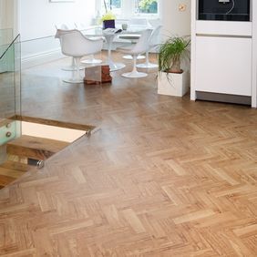 White dining table and chairs, with Nut Tree Oak colour Herringbone design laid floor 