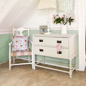 Light stone effect flooring in a hallway with a white console table 