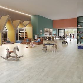 Oak effect flooring laid in a large nursery playroom with children playing