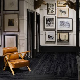 Art gallery with leather chair and Jet Black Ash flooring 