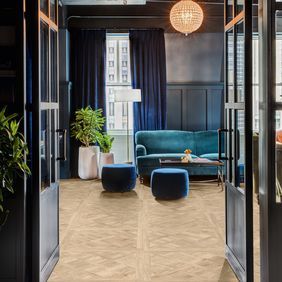 Oak effect flooring flowing from the hallway into the front room with navy decor