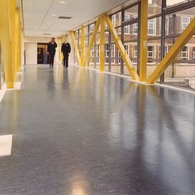 Large commercial corridor with dark coloured flooring