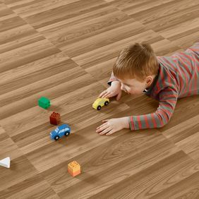 Little boy playing with cars featuring a ash wood effect flooring 