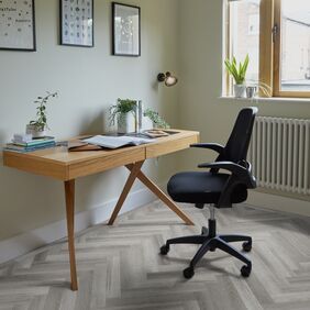 Grey coloured oak effect large parquet flooring with an office desk and chair