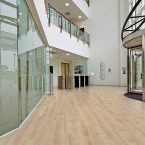 Large open space entrance with light wood effect flooring 