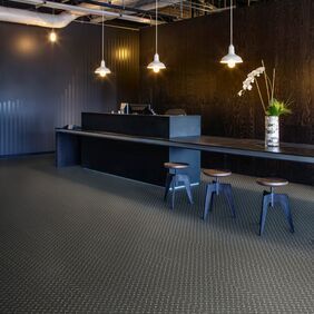 Black treadplate effect flooring in a dark reception area