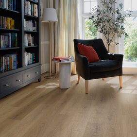 Oak effect flooring straight laid in a room with a bookcase and armchair